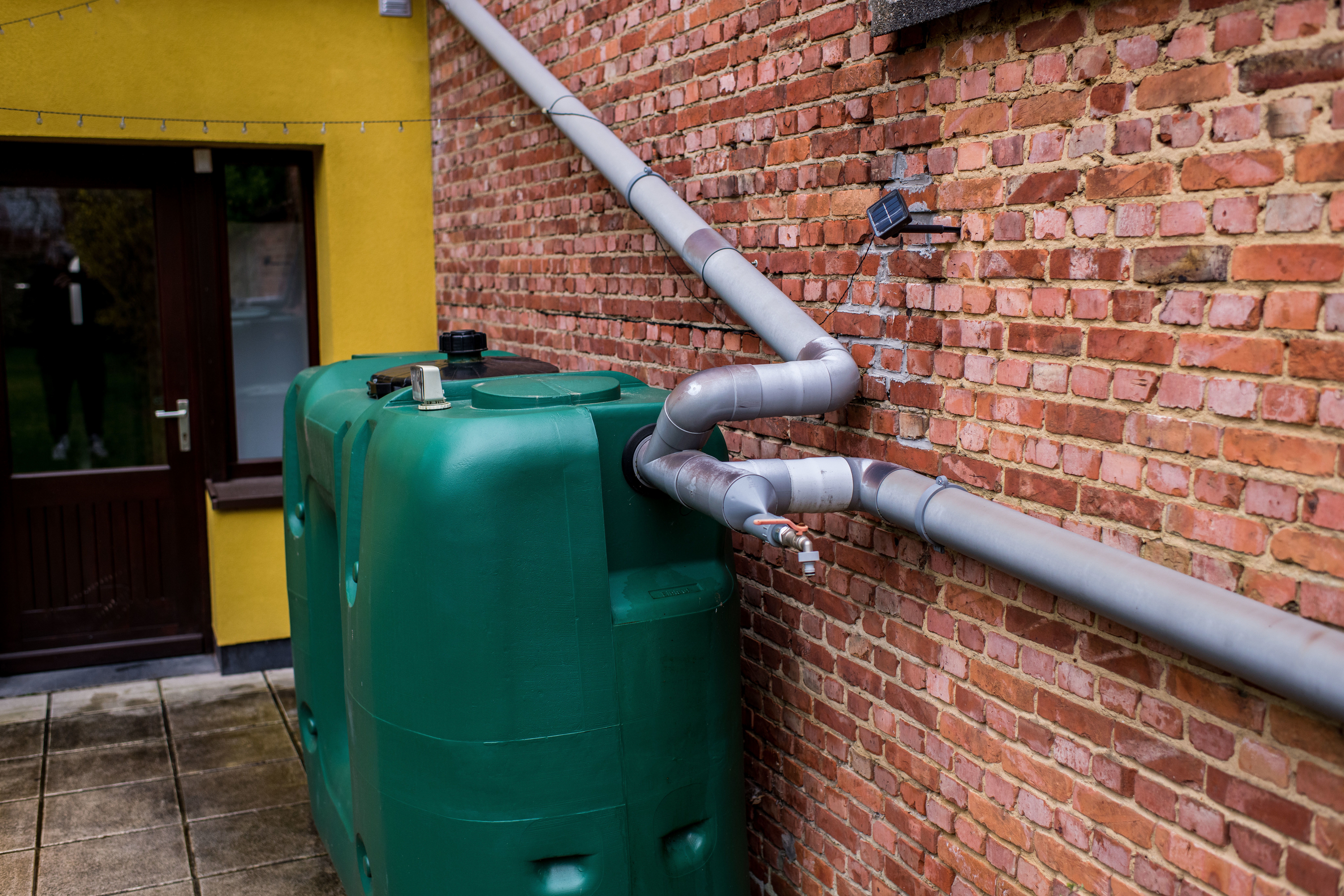 het regenwater wordt opgevangen in een grote regenton.afgekoppeld